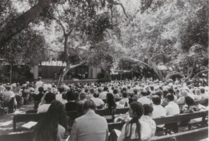 black and white film photo of an audience seated outdoors