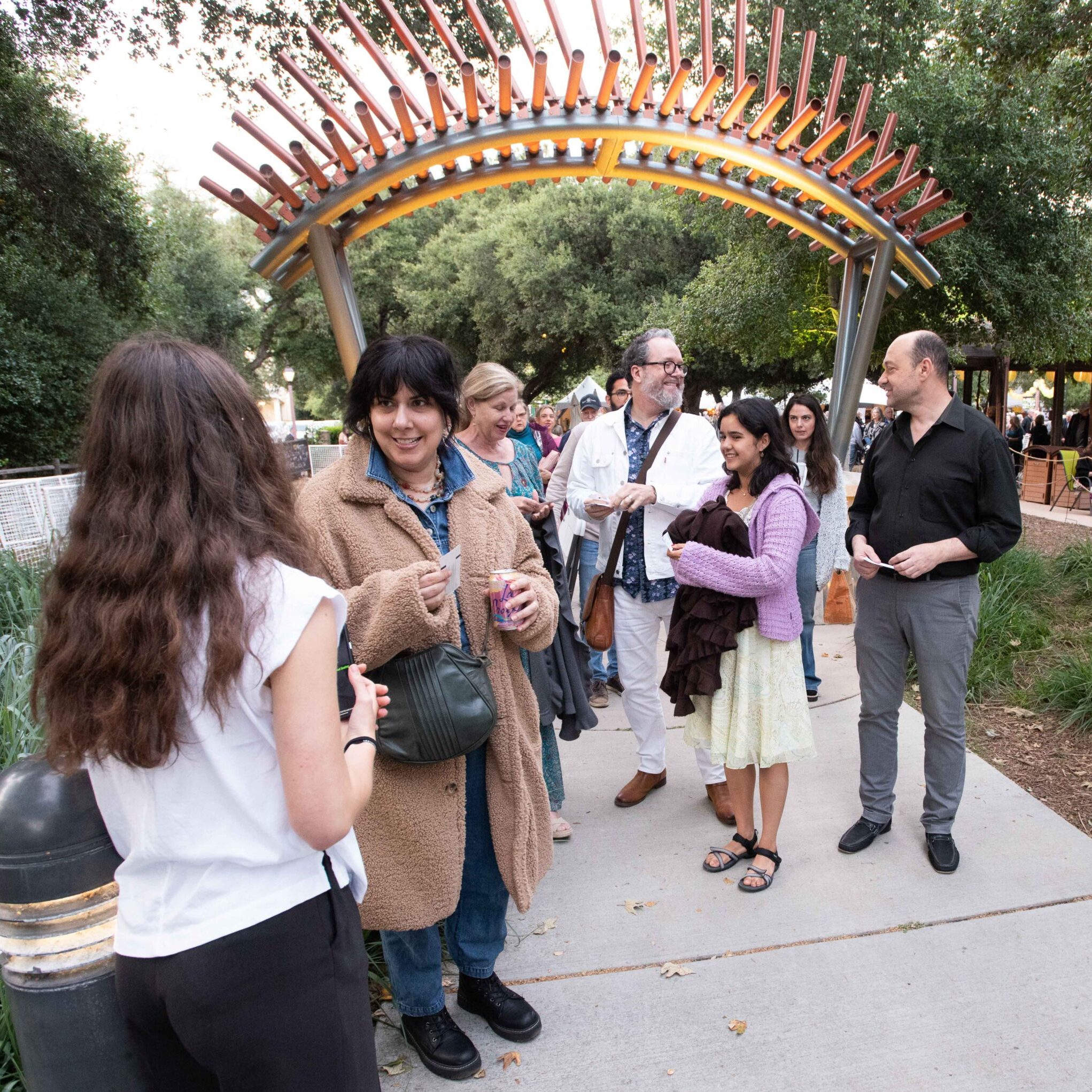 Patrons entering the bowl before a concert, conversing and smiling