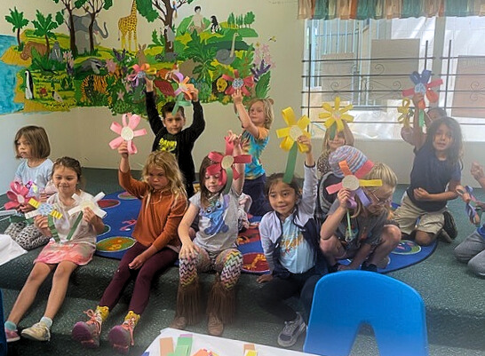 Campers showing off an arts and crafts project, paper flowers