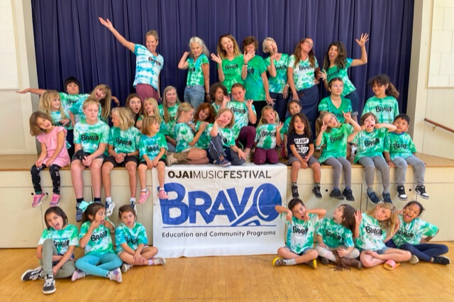 Campers and instructors smiling for group photo all wearing matching tie-dye Bravo t-shirts